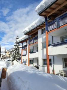 a snow covered yard in front of a building at Sun Matrei Apartments in Matrei in Osttirol