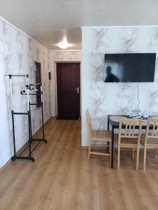 a dining room with a table and chairs and a tv at Viscosa Sadama tee külaliskorter in Kõrgessaare +4 photos
