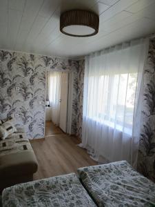 a bedroom with two beds and a wall with a window at Viscosa Sadama tee külaliskorter in Kõrgessaare