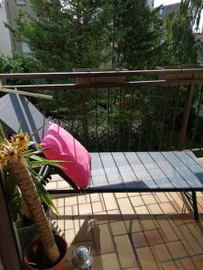 a bench with a pink pillow and a plant on a balcony at Appartement,clair au calme avec balcon in Fontenay-sous-Bois