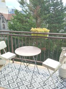 two chairs and a table on a balcony with a plant at Appartement,clair au calme avec balcon in Fontenay-sous-Bois