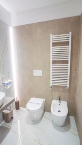 a white bathroom with a toilet and a sink at VIBINUM Bed & Breakfast in Bovino