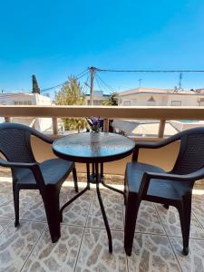 a table and two chairs on a patio at Armonia Apartments in Archangelos
