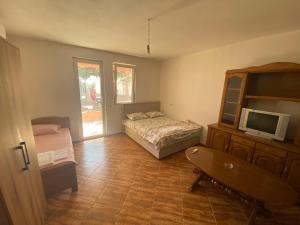 a bedroom with a bed and a tv in it at Apartmani Adelisa in Šušanj