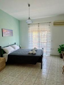 a bedroom with a bed and a large window at Armonia Apartments in Archangelos