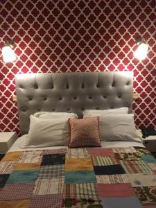 a bedroom with a bed with a large headboard at Hotel Kamanga in Tomar