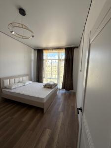 a bedroom with a bed and a large window at Lake in Bosteri