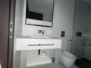 a white bathroom with a sink and a toilet at Nordis 22 Deluxe Room Mamaia Nord in Mamaia Sat/Năvodari