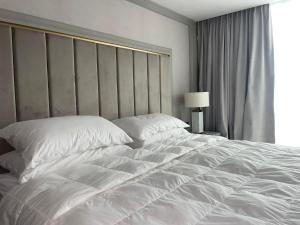 a large white bed in a hotel room at Nordis 22 Deluxe Room Mamaia Nord in Mamaia Sat/Năvodari