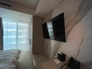 a bedroom with a flat screen tv on the wall at Nordis 22 Deluxe Room Mamaia Nord in Mamaia Sat/Năvodari
