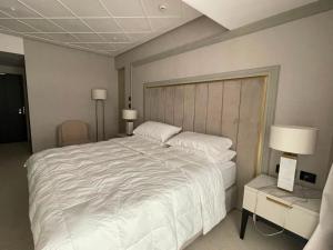 a bedroom with a large white bed and two lamps at Nordis 21 Deluxe Room Mamaia Nord in Mamaia Sat/Năvodari
