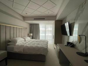 a bedroom with a large bed and a window at Nordis 21 Deluxe Room Mamaia Nord in Mamaia Sat/Năvodari