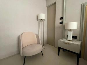 a room with a chair and a table with a lamp at Nordis 20 Deluxe Room Mamaia Nord in Mamaia Sat/Năvodari