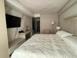 a hotel room with a large bed and a television at Nordis 20 Deluxe Room Mamaia Nord in Mamaia Sat/Năvodari