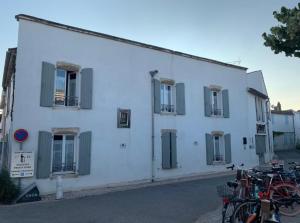 a white building with windows and bikes parked in front of it at Chambre d'hôtes Hôte des Portes Île de Ré in Les Portes