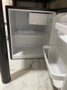 an empty refrigerator with its door open in a kitchen at AmurRelaxCreative in Khmelnytskyi