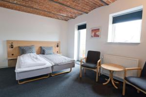 a bedroom with a bed and a table and a chair at Hovborg Kro in Hovborg