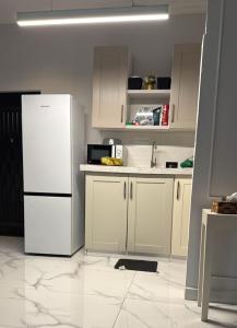 a kitchen with white cabinets and a white refrigerator at Parkside City Apts in Accra