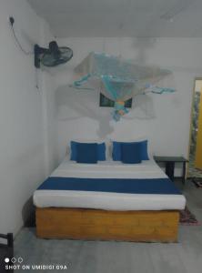 a bed with blue pillows in a room at Rithu Homestay in Sigiriya