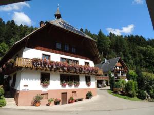 a building with flowers on the balcony of it at Obergießhof Waldbauernhof in Hornberg