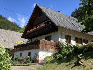a white house with flowers on the balcony at Obergießhof Waldbauernhof in Hornberg