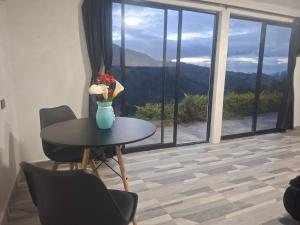 a table with a vase of flowers on it at Alojamiento Campestre Barachel in Pamplona