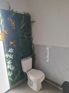 a bathroom with a toilet with a painting on the wall at Alojamiento Campestre Barachel in Pamplona