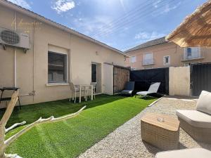a small backyard with a lawn with a couch and chairs at Le Cocon Tropical - Cosy, Clim, Centre-ville, Jardinet, 2 personnes in Miramas