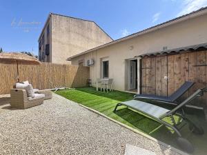 a patio with a chair and an umbrella and grass at Le Cocon Tropical - Cosy, Clim, Centre-ville, Jardinet, 2 personnes in Miramas