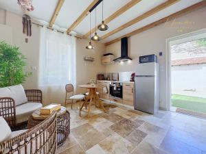 a living room with a table and a refrigerator at Le Cocon Tropical - Cosy, Clim, Centre-ville, Jardinet, 2 personnes in Miramas
