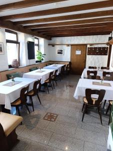 a row of tables in a restaurant with white tables and chairs at Hotel Exquisite in Bobenheim am Berg