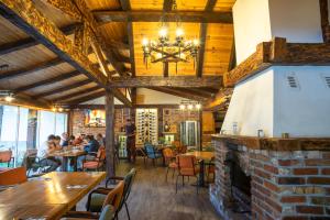 ein Restaurant mit einem gemauerten Kamin und Gästen, die an Tischen sitzen in der Unterkunft Hotel Enigma in Žabljak