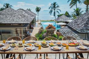 a table with plates of food on top of a resort at Villa Ayundra in Lipa Noi