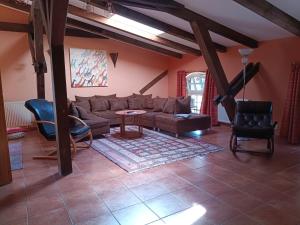 a living room with a couch and a table and chairs at Ferien am Schloss - Wohnung 6 "der Pferdestall", Ferienwohnung am Badesee in Behren-Lübchin