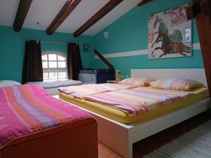 two beds in a room with blue walls at Ferien am Schloss - Wohnung 6 "der Pferdestall", Ferienwohnung am Badesee in Behren-Lübchin