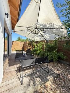 a patio with a bench and an umbrella at Cozy House in Świnoujście