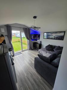 a living room with a couch and a tv at Lownie lodge in Leysdown-on-Sea
