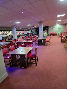 a dining room with tables and chairs in a cafeteria at Lownie lodge in Leysdown-on-Sea