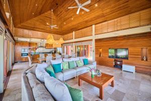 a large living room with a couch and a tv at Villa Ayundra in Lipa Noi