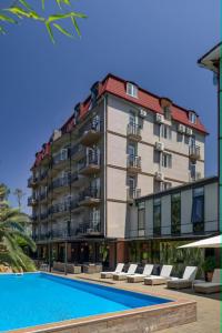 a large building with a swimming pool in front of it at Iveria Elli Hotel in Shekhvetili