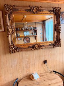 a mirror hanging on a wall with a table at Mieszkanie Pod Sztolniami- Riese in Walim