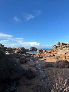 a beach with rocks and the ocean in the background at Molène Centre Ville Lannion in Lannion
