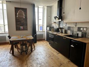 a kitchen with a wooden table and a wooden floor at Molène Centre Ville Lannion in Lannion