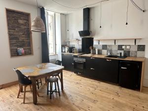 a kitchen with a wooden table and a wooden floor at Molène Centre Ville Lannion in Lannion +10 photos