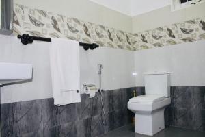 a bathroom with a white toilet and a shower at Lodge 52 Negombo in Negombo