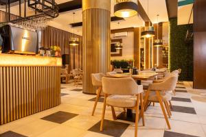 a restaurant with a bar and tables and chairs at Pollock Hotel, Ribarska Banja in Ribarska Banja