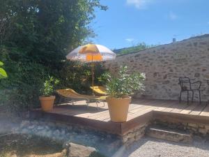 a wooden deck with a table and an umbrella at Près du Vicomte in Maincy