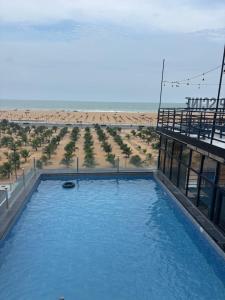 a large swimming pool with a beach in the background at Chez Gero Aeroport in Cotonou
