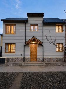 a house with a wooden door in front of it at Destino Patagonia in Esquel