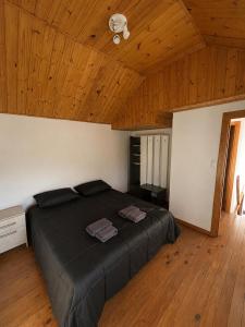 a large bed in a room with a wooden ceiling at Destino Patagonia in Esquel